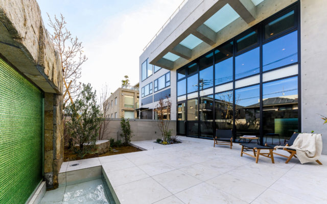 H RESIDENCEの中庭。大開口サッシと大きなガラス庇、石張りの床と水盤を配した都市型住宅の外部空間。（設計監理：an DeSign & Associates）