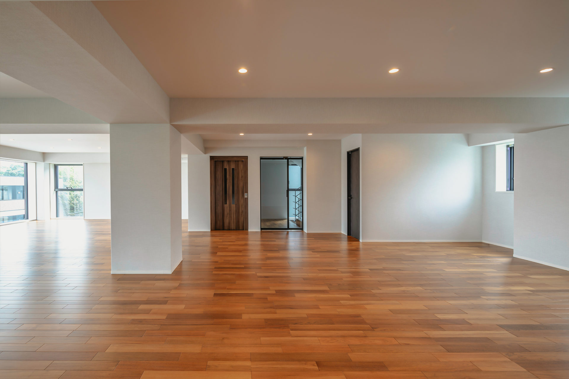 H RESIDENCEの室内空間。無垢フローリングの広々としたワンルームに大開口窓から光が差し込み、都市の眺望を取り込む開放的なインテリア（設計監理：an DeSign & Associates）