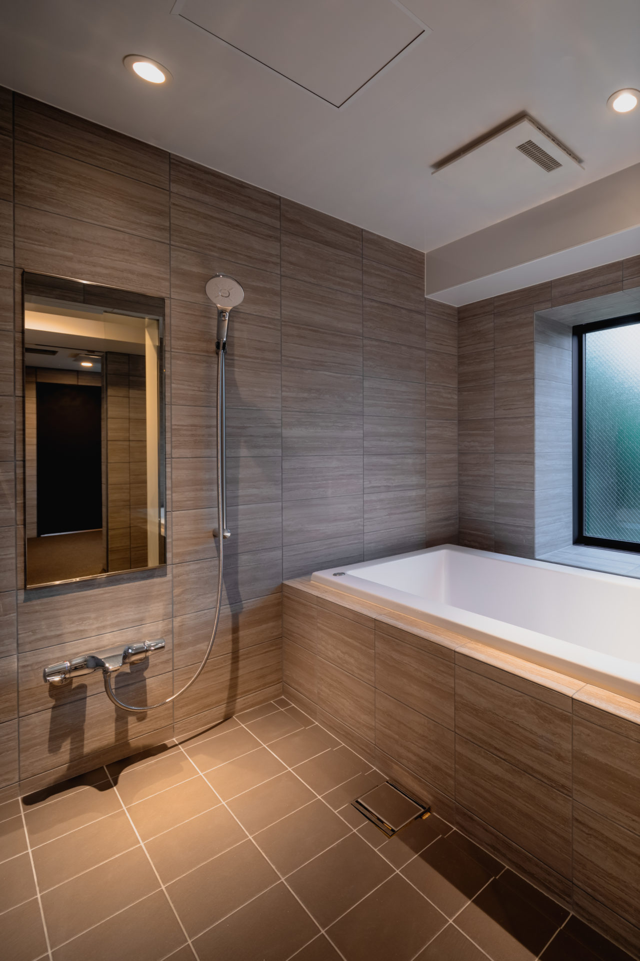 H RESIDENCEのバスルーム。ライムストーンで統一した落ち着きある浴室。（設計監理：an DeSign & Associates）