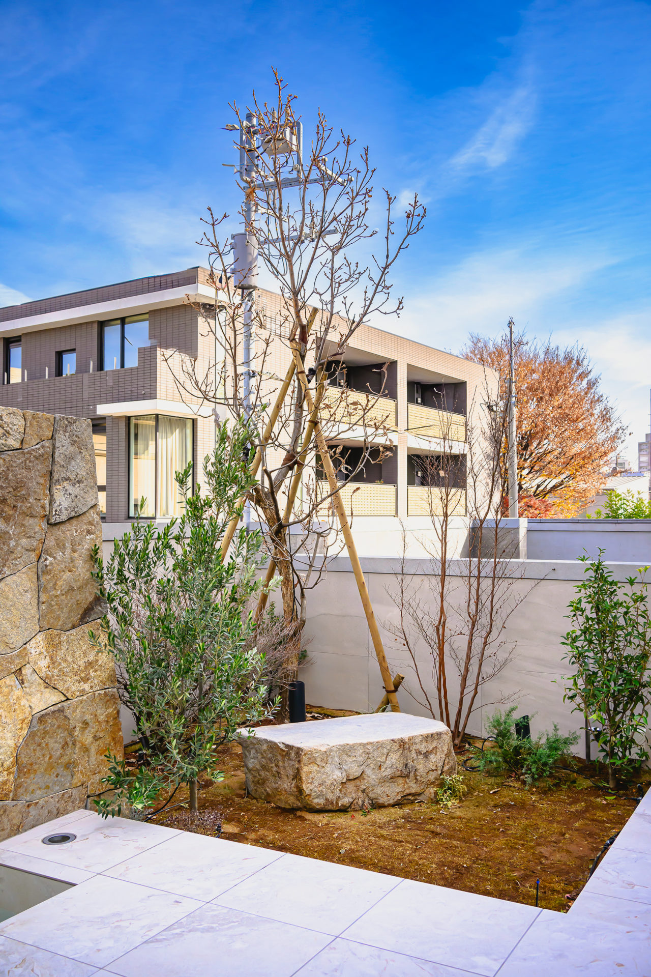 H RESIDENCEの中庭。石張りの床と水盤を配した都市型住宅の外部空間。